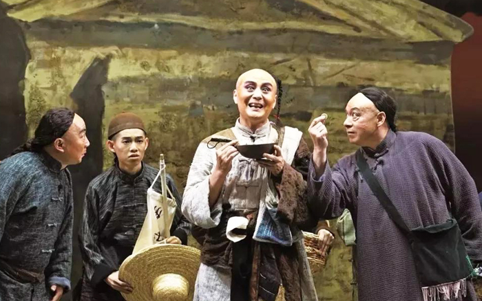 Vũ Huấn mặc trang phục kỳ dị như một anh hề mua vui cho khách qua đường, âu cũng là mong có thêm tiền thưởng tặng.