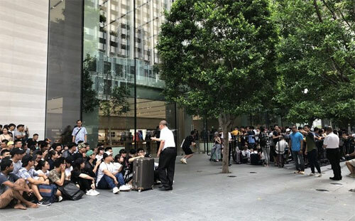 Đông đúc nhất thế giới chính là Apple Store tại Singapore, nơi có hàng trăm người đã bay từ Việt Nam sang từ ngày 19/9 để xếp hàng. 80-90% những người xếp hàng hôm nay là người Việt, một thương gia iPhone ở TP HCM cho biết. Mỹ Linh (thứ hai từ trái sang) có số thứ tự 001, tức sẽ trở thành người đầu tiên được mua iPhone tại Apple Store trên đường Orchard. Cô đi cùng nhóm bạn 5 người từ TP HCM và có mặt tại Singapore từ đêm qua.