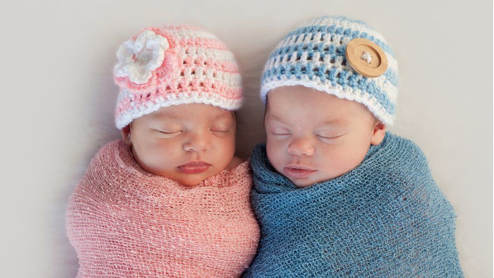 Cặp song sinh năm tuần tuổi với trang phục hồng và xanh. Bạn có biết đâu là trai, đâu là gái? 