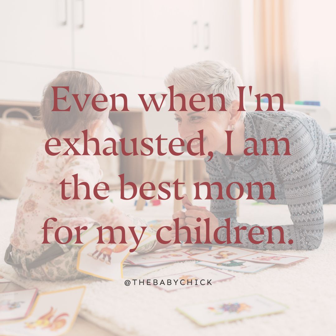 Một người mẹ đang tập plank với con gái trong phòng chơi của họ ở hậu cảnh với lời khẳng định thiên chức làm mẹ được viết trên hình ảnh của cô ấy.